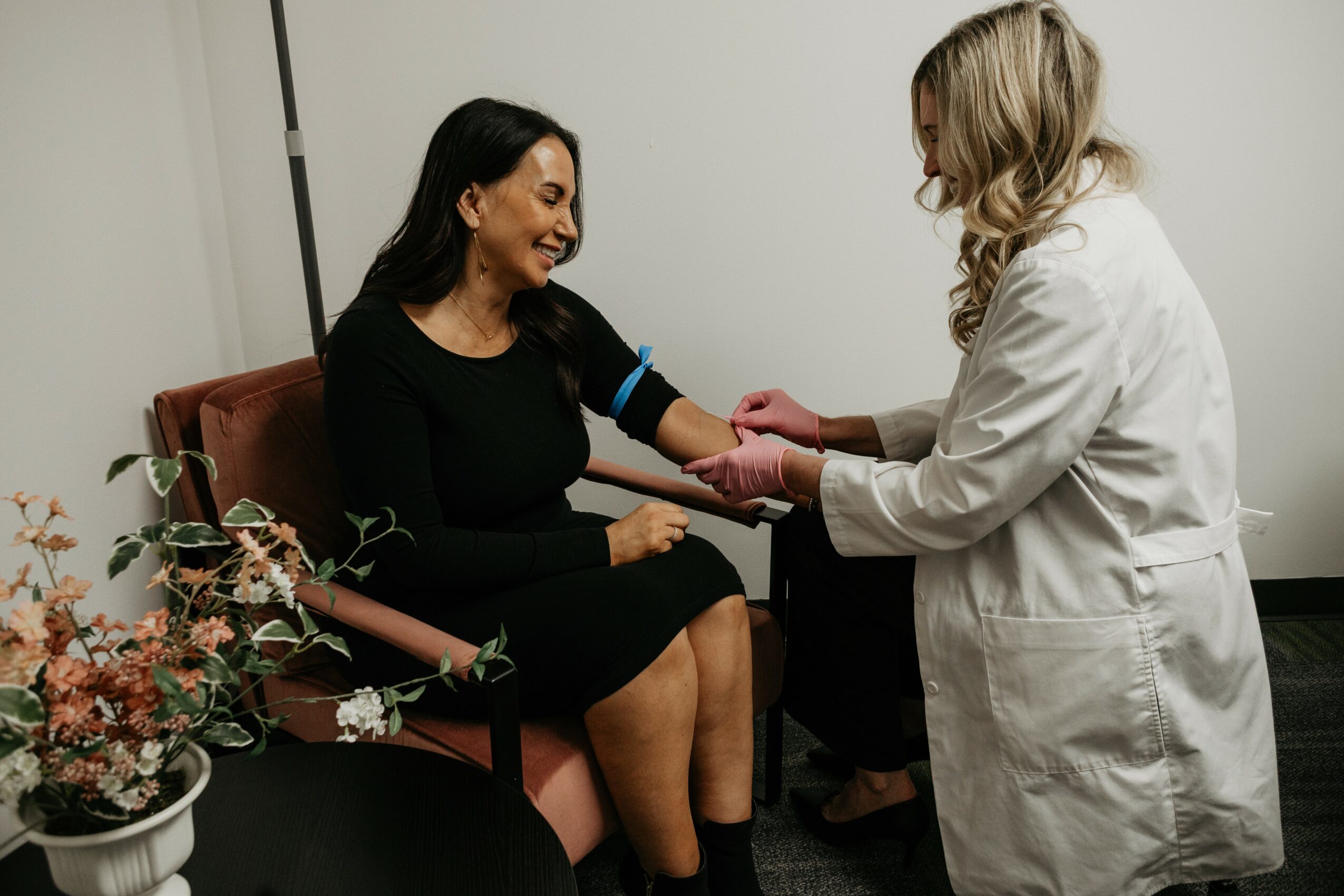 Medical professional taking a woman's blood pressure in a clinical setting.
