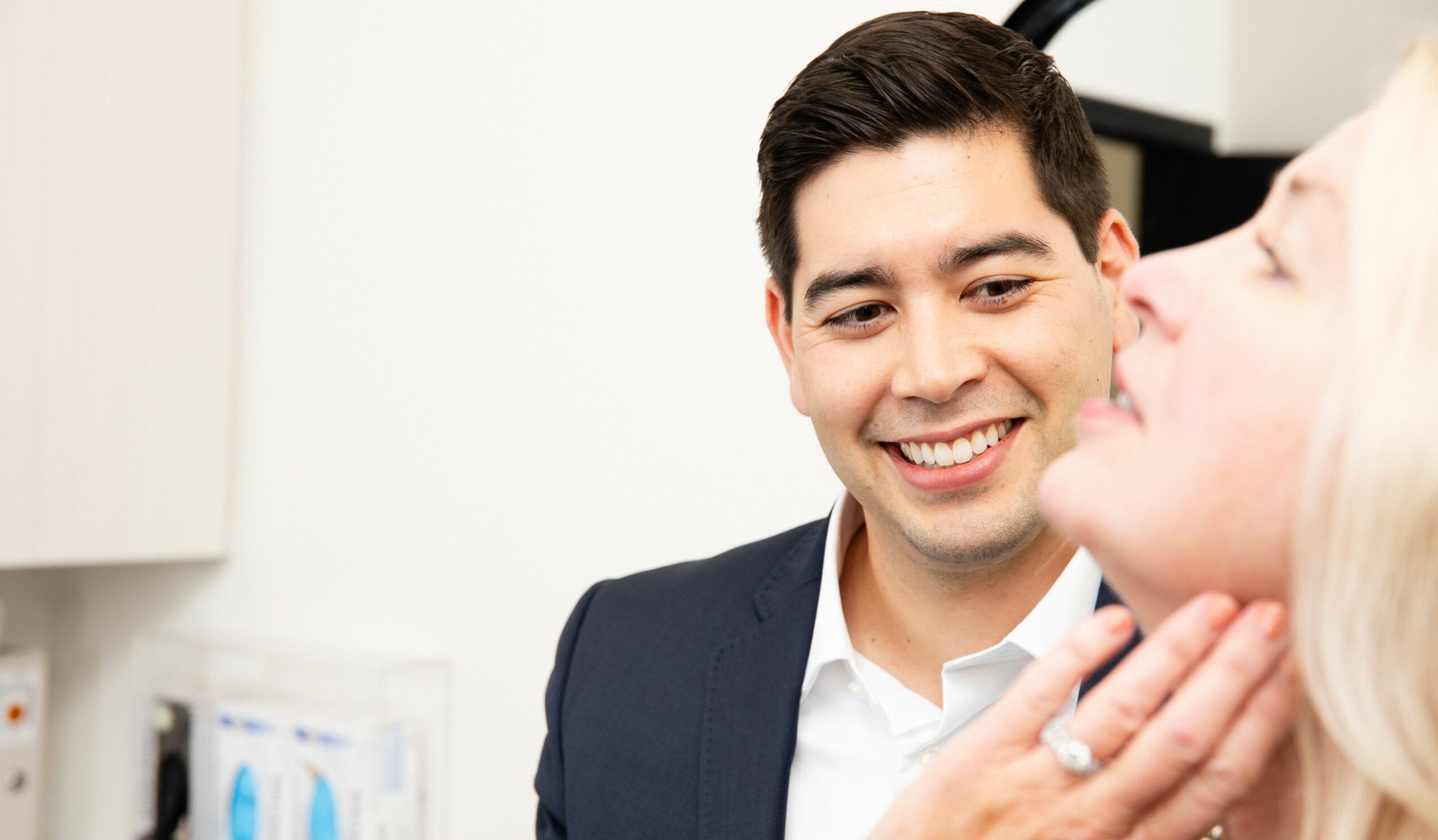Man smiling and looking at a woman in an indoor setting.