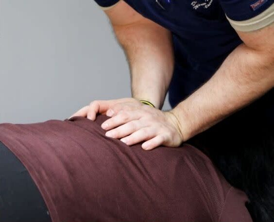 Person performing chest compressions on another person lying face down.