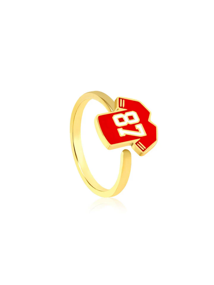 Gold ring with a red and white tag displaying the number 18, viewed from the side.