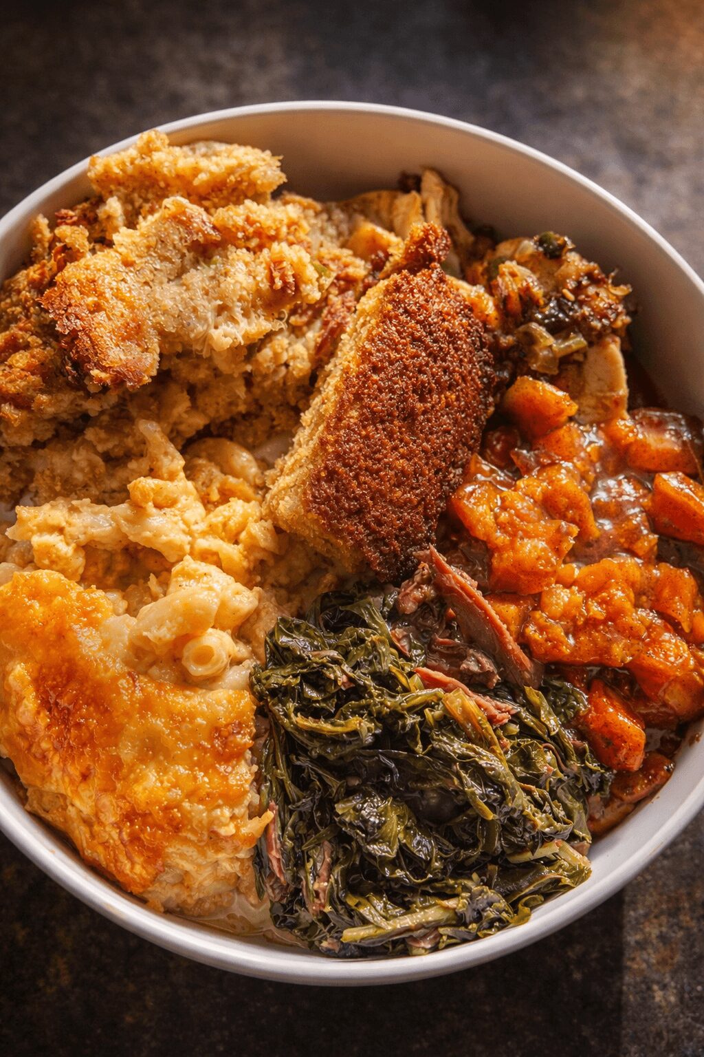 Assorted fried and cooked foods in a bowl, including breaded items, vegetables, and a fried patty.