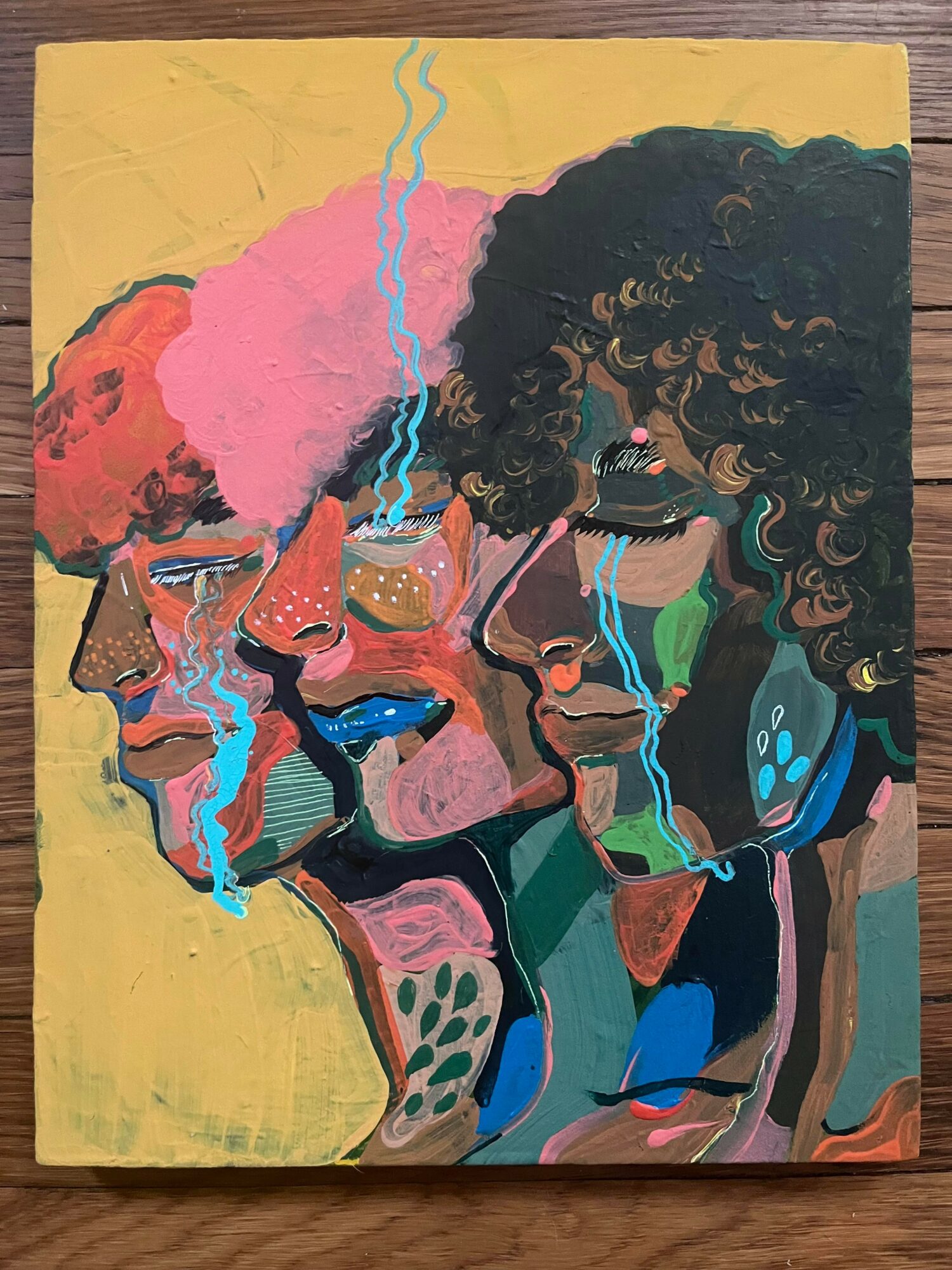Four faces with colorful, abstract features and flowing blue lines, set against a yellow background.