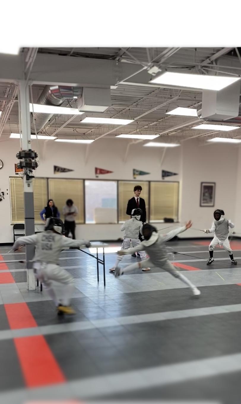 People practicing martial arts in a gym with flags and mirrors, some performing kicks and stances, others observing or coaching.