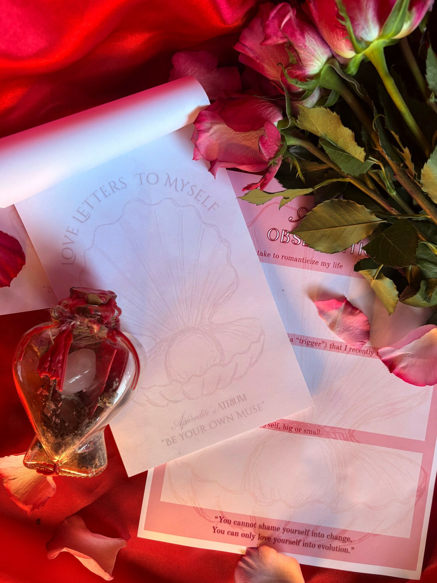 Bouquet of pink roses, a heart-shaped glass ornament, and a letter with a faint drawing, all on pink paper.