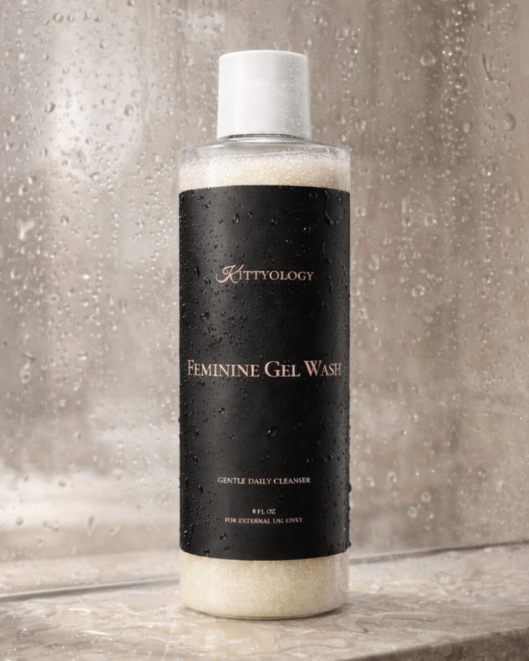 Bottle of feminine gel wash with a black label, placed on a wet surface with a foggy background.