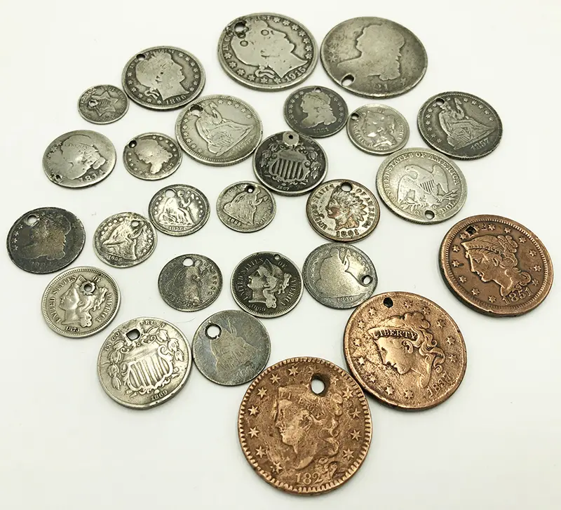 Collection of various coins, some silver and some copper, arranged on a white background.