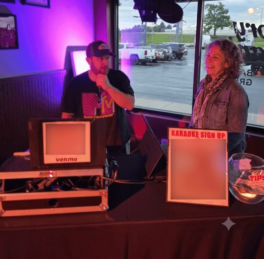Two people standing at a karaoke sign-up table inside a venue, with a window showing parked cars outside.