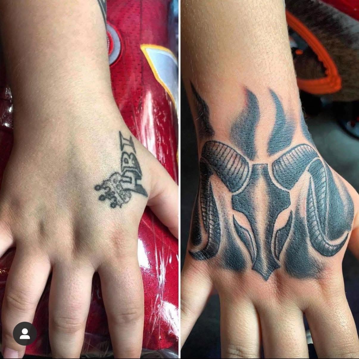 Two hands with tattoos, one with a small crown tattoo and the other with a large flame and skull design.