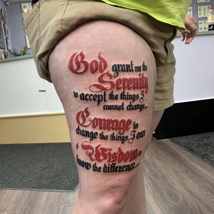 Tattoo on person's thigh with a quote about faith and wisdom in red and black text.