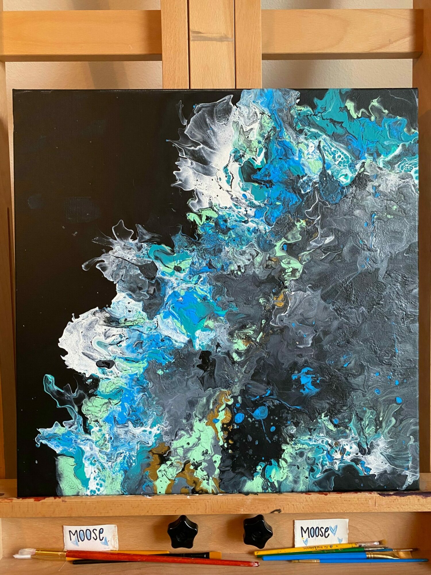 Abstract painting with blue, white, and gray colors on a black background.