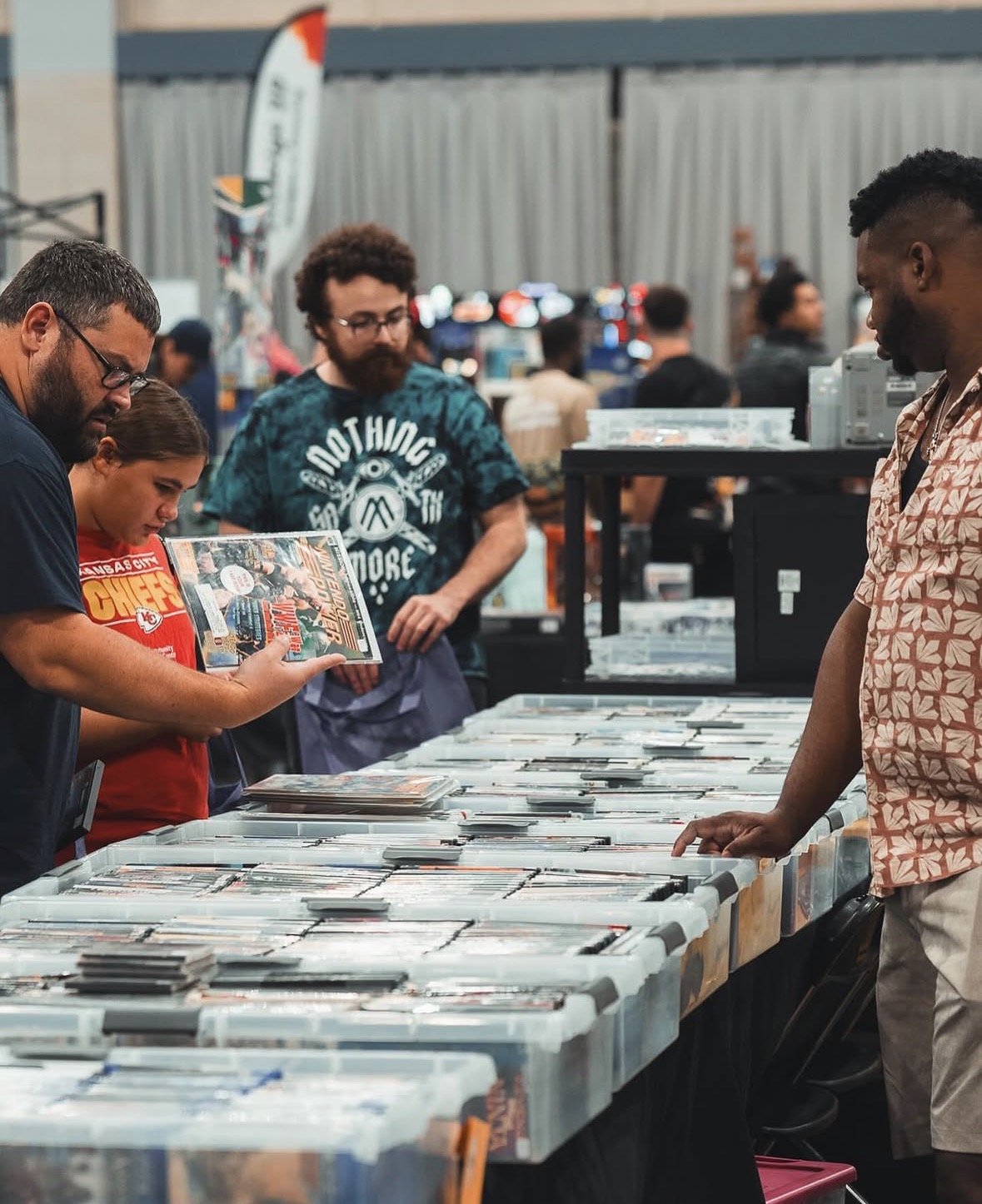People browsing vinyl records at an outdoor market stall with tables full of records, in a busy setting.