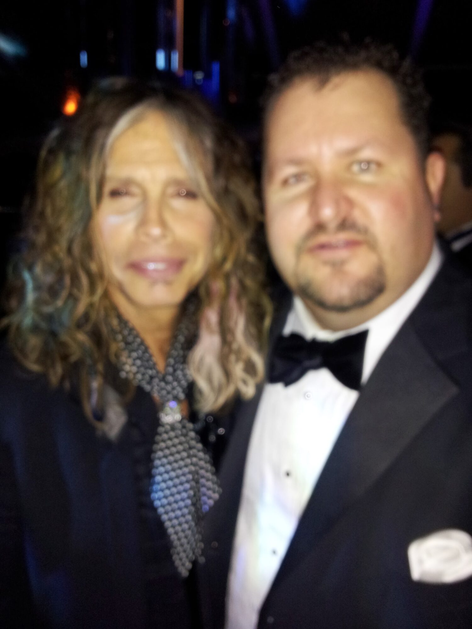 A woman and a man in formal attire posing together at an event.