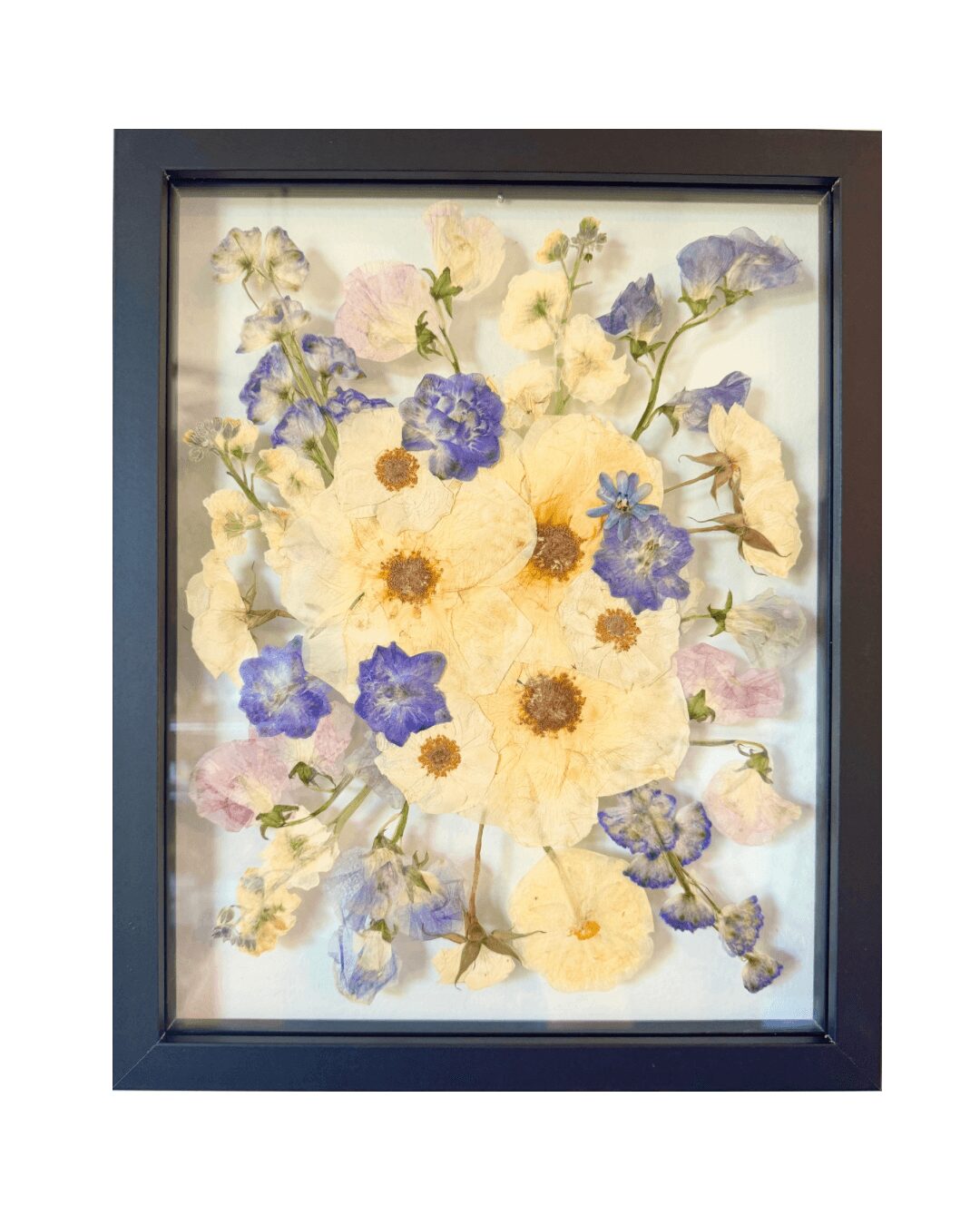Framed watercolor painting of yellow and purple flowers with green leaves, on a white background.