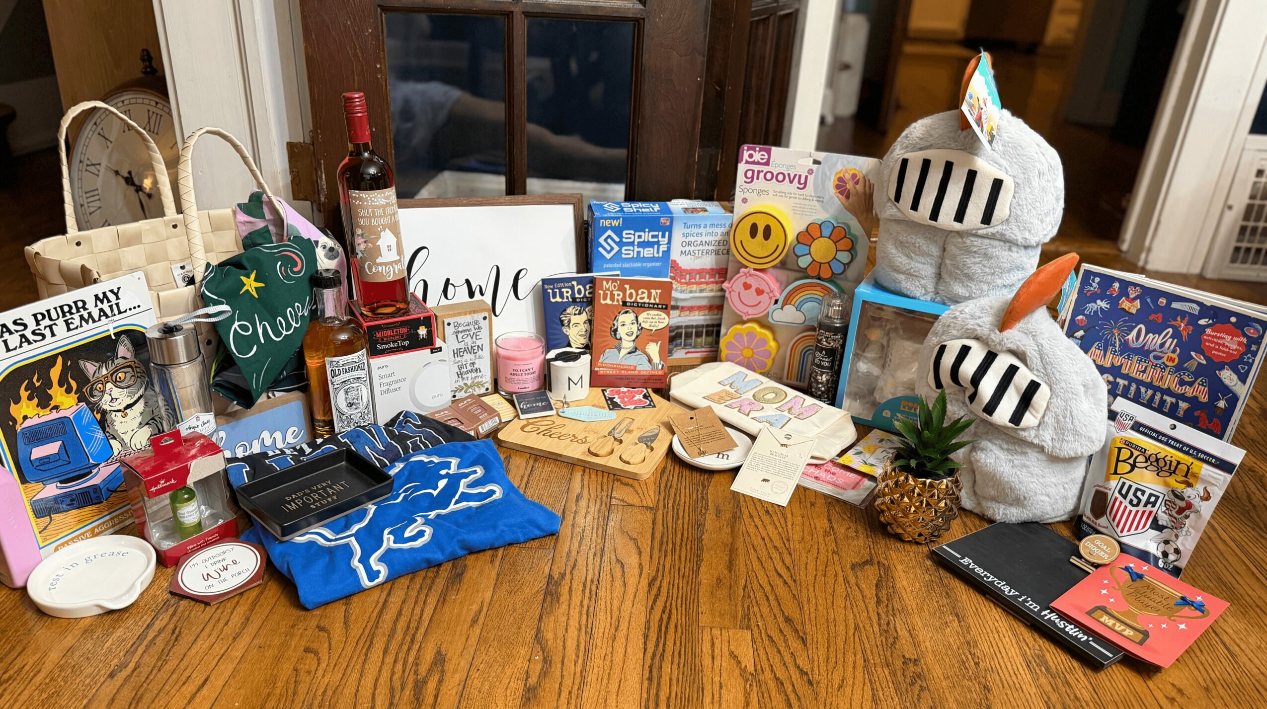Table with various gifts, snacks, and holiday decorations, including socks, chocolates, and small plants.