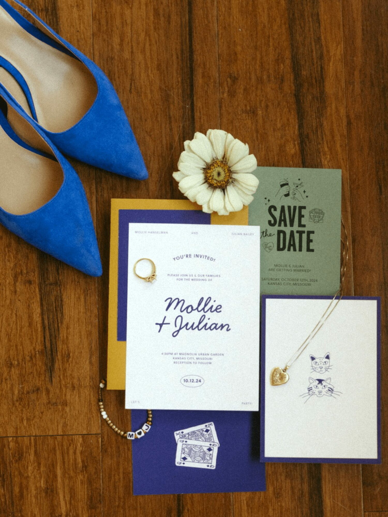 Blue high heels, flower, wedding invitation, and greeting card on wooden floor.