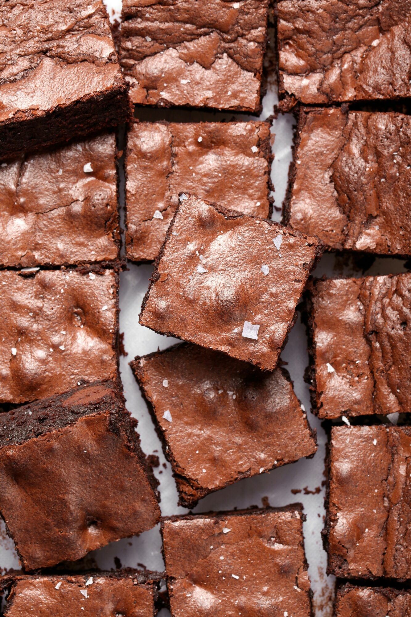 Close-up of broken chocolate brownies with uneven edges and a slightly cracked surface.