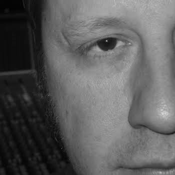 Close-up of a person's face, showing one eye and part of the nose, in black and white.