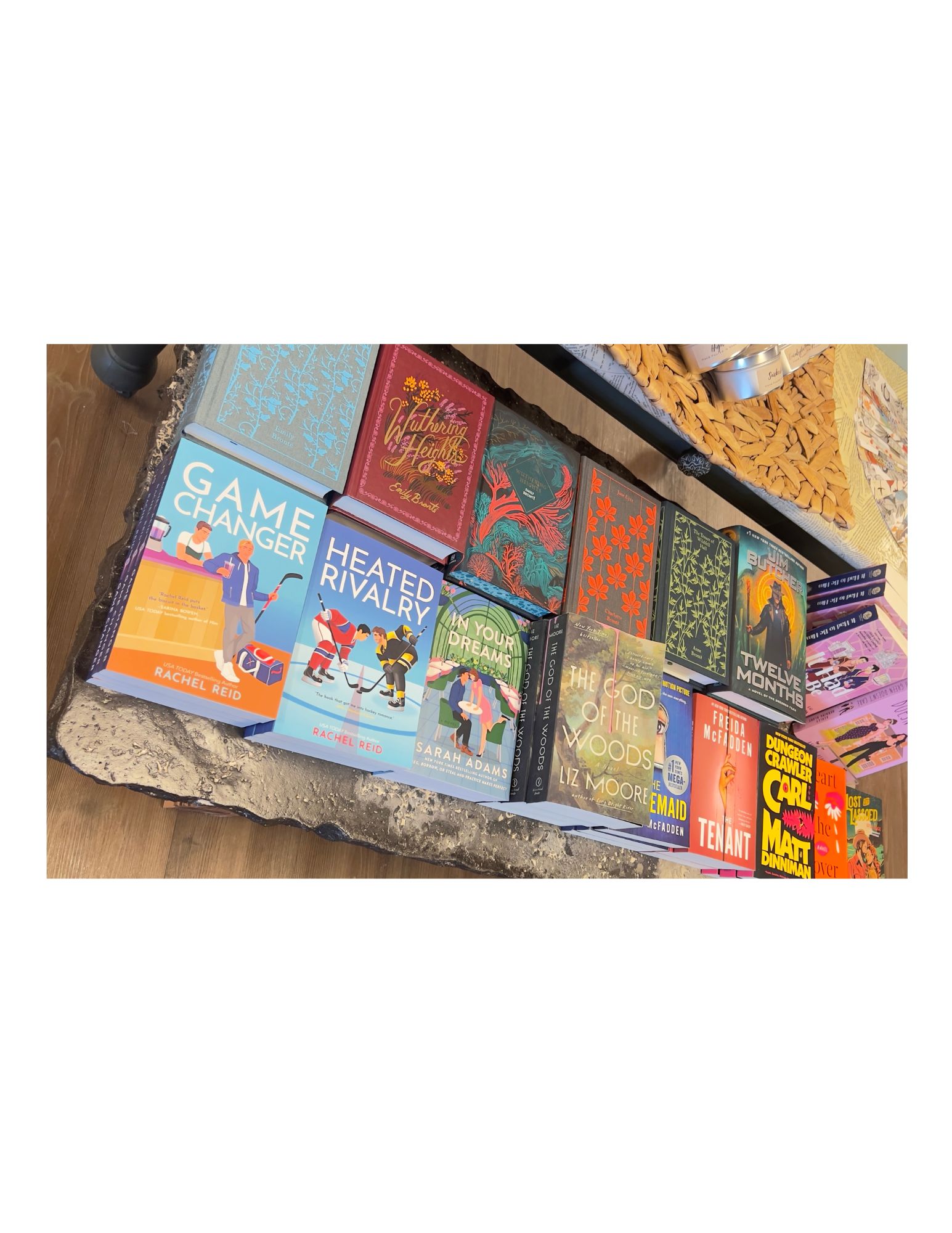 Books and board games arranged on a table, including titles like 'Heated Rivalry' and 'Game Changer'.
