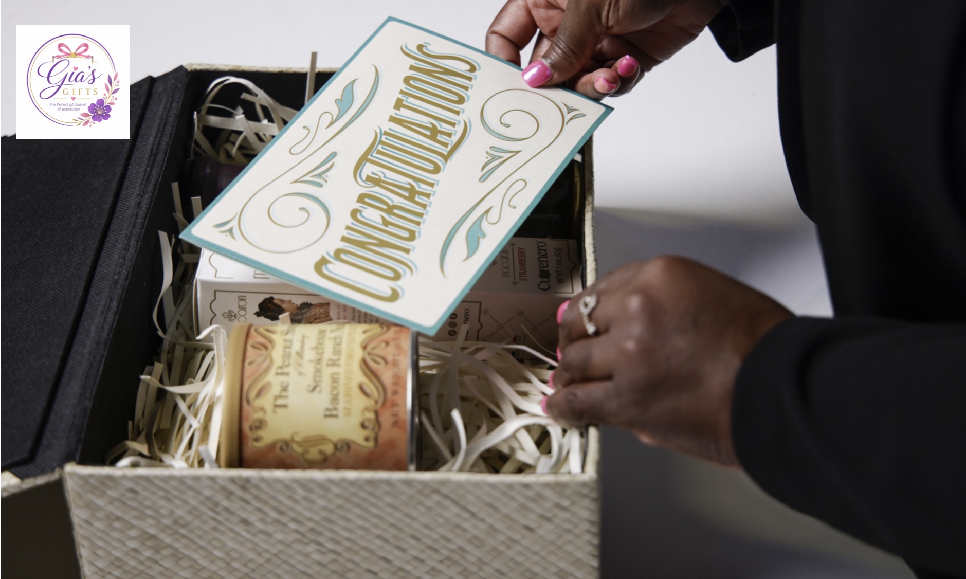 Person holding a card labeled 'Congratulations' above a gift box with a candle inside.