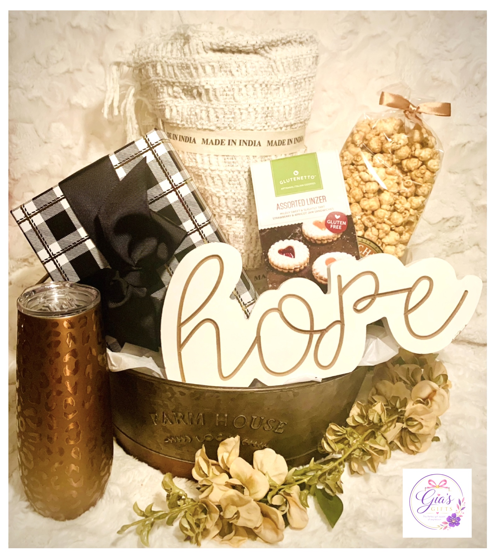 Decorative arrangement with a bowl, a jar of popcorn, a candle, a gift box, and a 'hope' sign, with flowers.