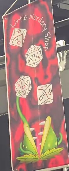 Red and black sign with dice illustrations and a green frog, titled 'Little Nerdery Swap'.