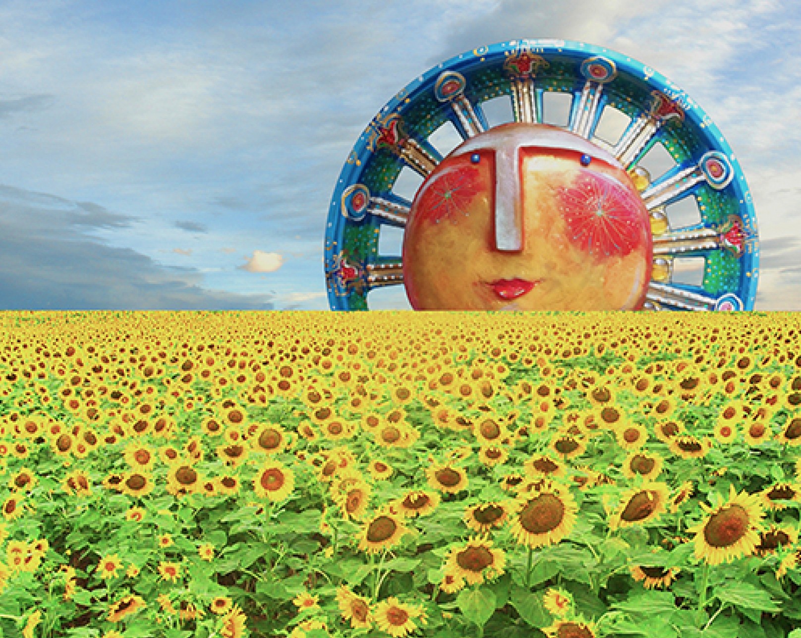 A large colorful Ferris wheel with a face-like design in the background, over a field of sunflowers under a partly cloudy sky.