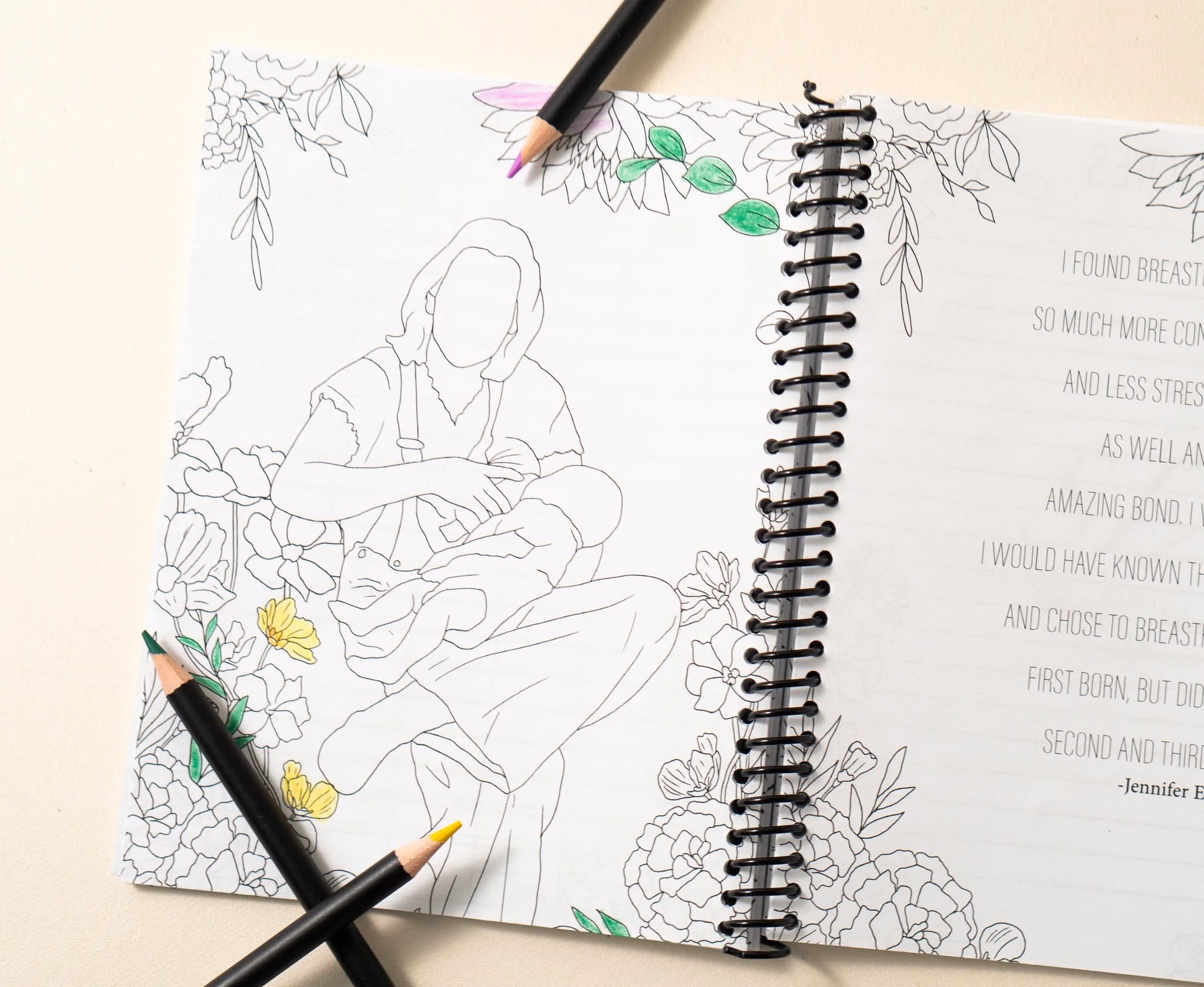 Open sketchbook with a line drawing of a person sitting, surrounded by floral designs, and a partially visible page with text.