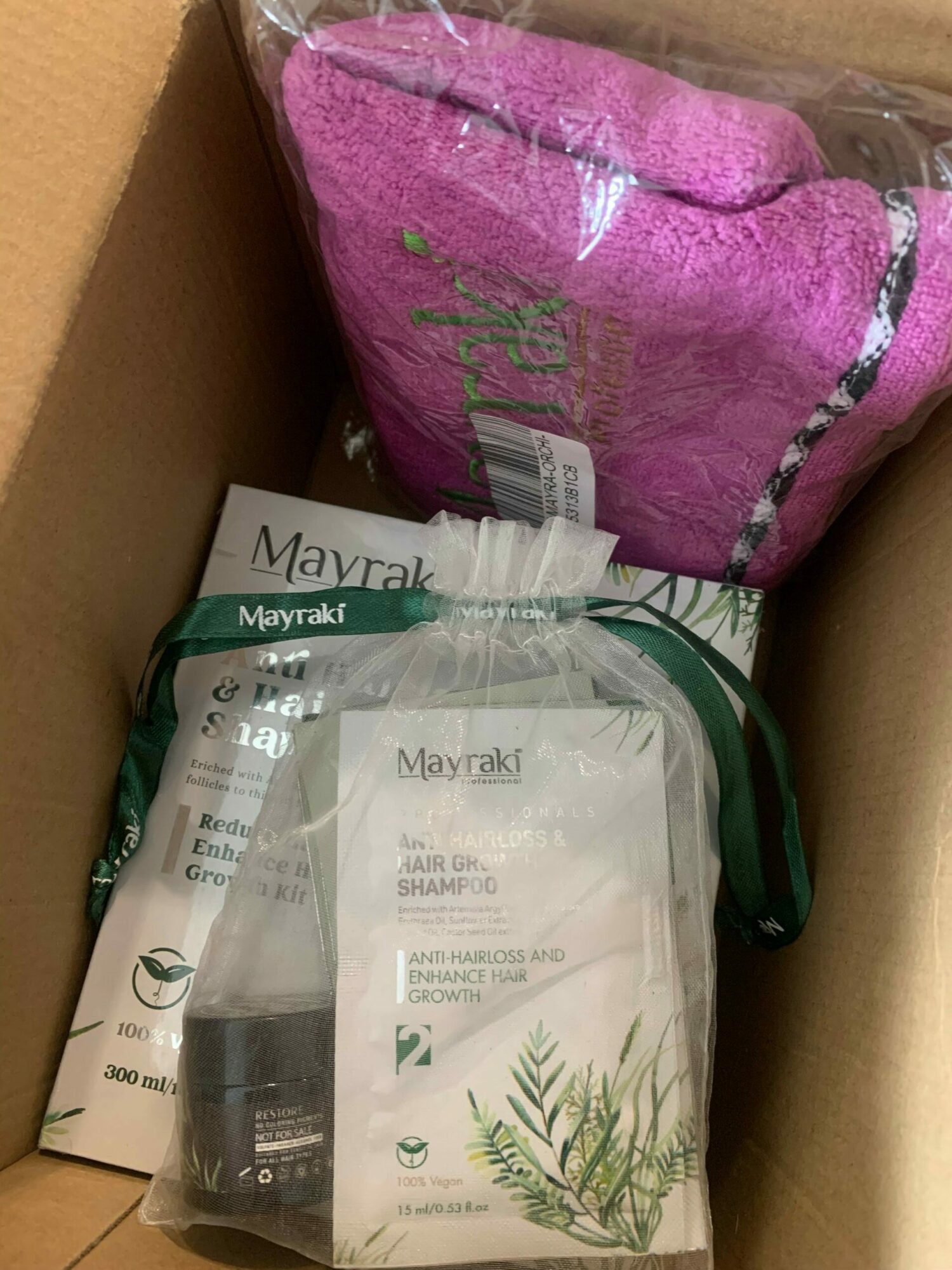 Pink towel, clear plastic bag, and paper items inside a cardboard box.