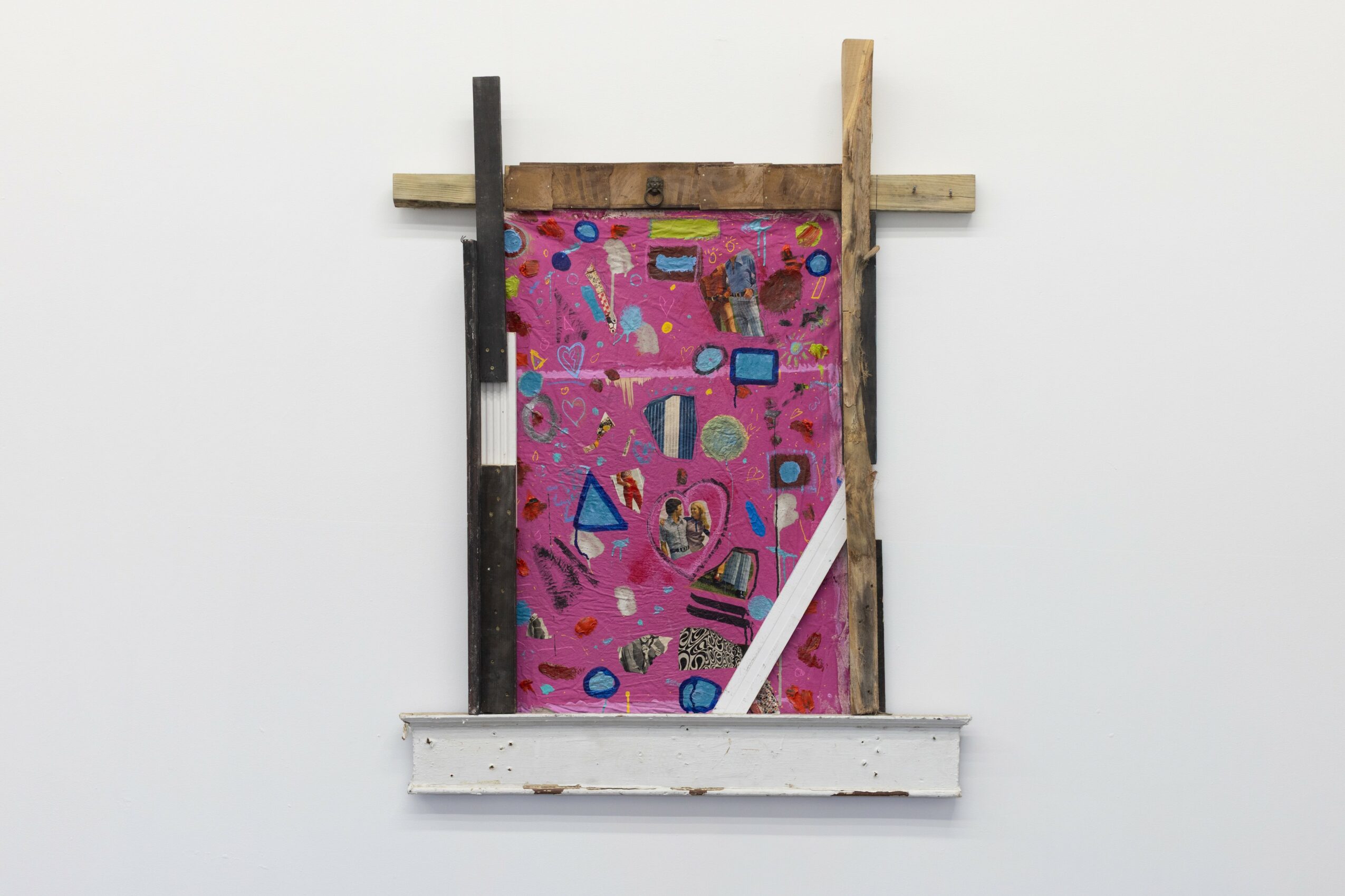 Colorful abstract artwork with various shapes and patterns, framed by wooden and painted elements, displayed on a white wall.
