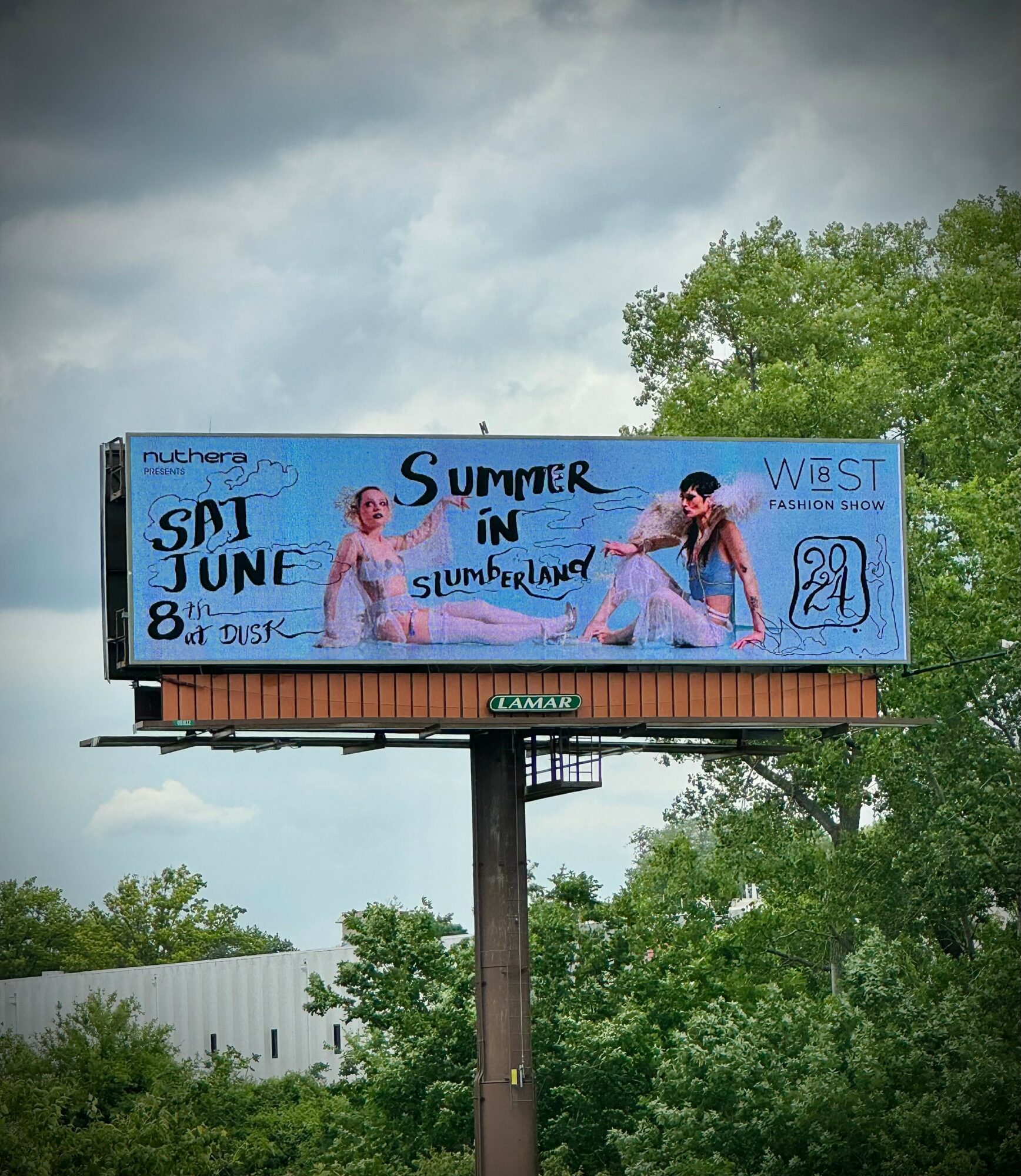 Billboard advertising a summer event with two children in swimsuits, text about June 24th, and a blue background.