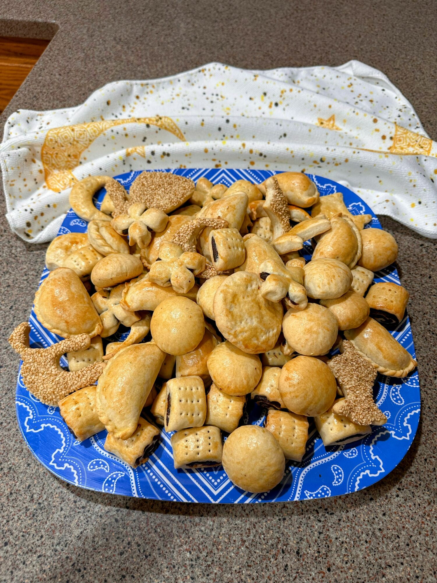 Plate of assorted cooked mushrooms on a blue patterned plate, with a white cloth with gold stars in the background.