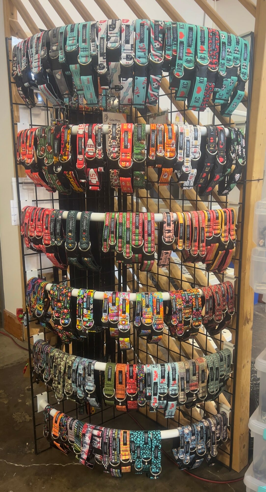 Display rack with multiple rows of colorful socks in packaging, arranged vertically, with a wooden frame background.