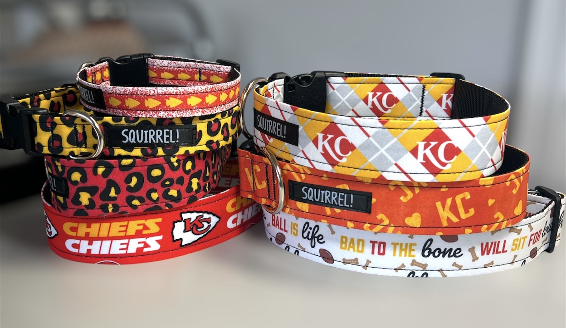 Two stacks of pet collars with Kansas City Chiefs and Kansas City Royals themes, colorful patterns, and team logos.