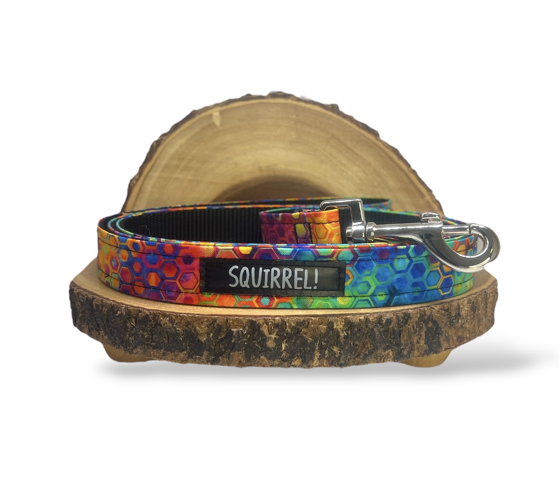 Colorful dog collar with a tag reading 'SQUIRREL!' on a wooden slice, with a white background.