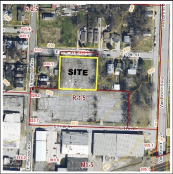 Aerial view of a site outlined in yellow, surrounded by streets and buildings, with labels and measurements visible.