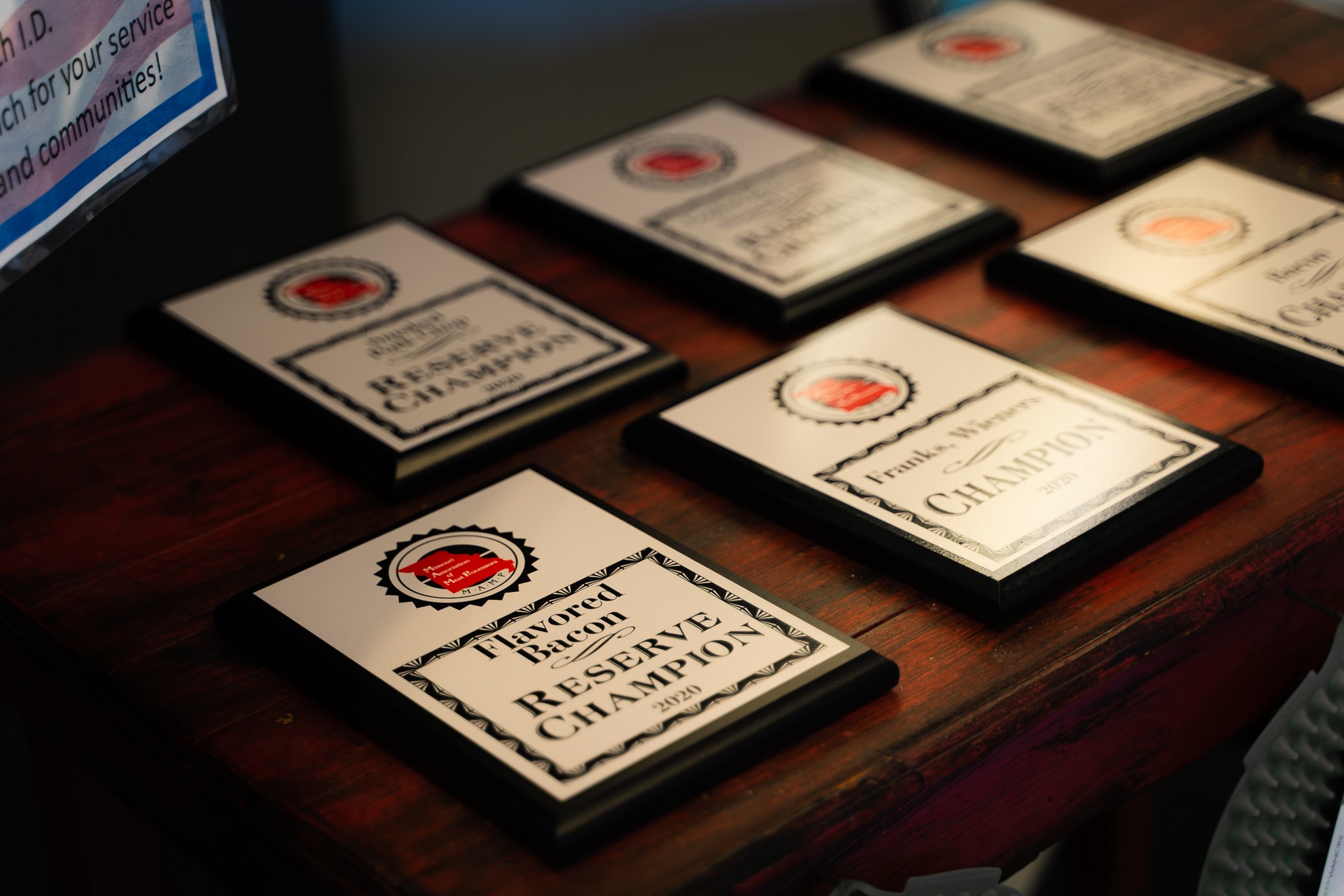 Several identification cards or badges are arranged on a dark wooden surface, with a computer monitor partially visible in the background.