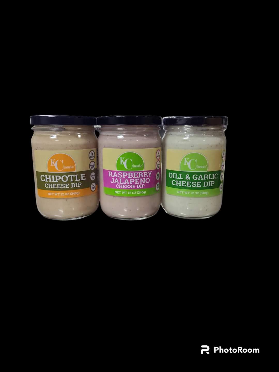 Three jars of cheese dip with different flavors and labels, placed side by side on a black background.