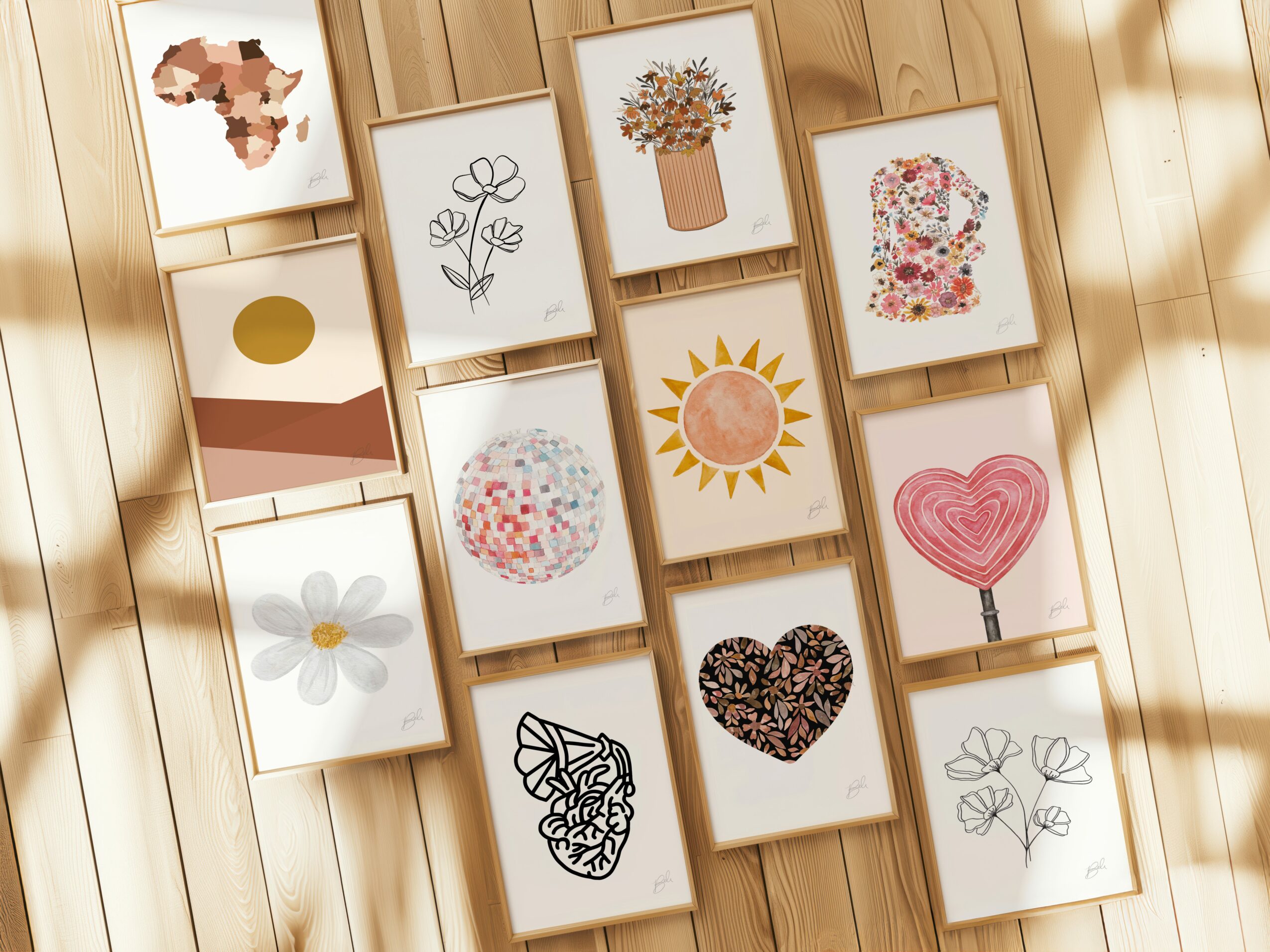 Collection of framed artwork on wooden wall, including flowers, hearts, and abstract designs.