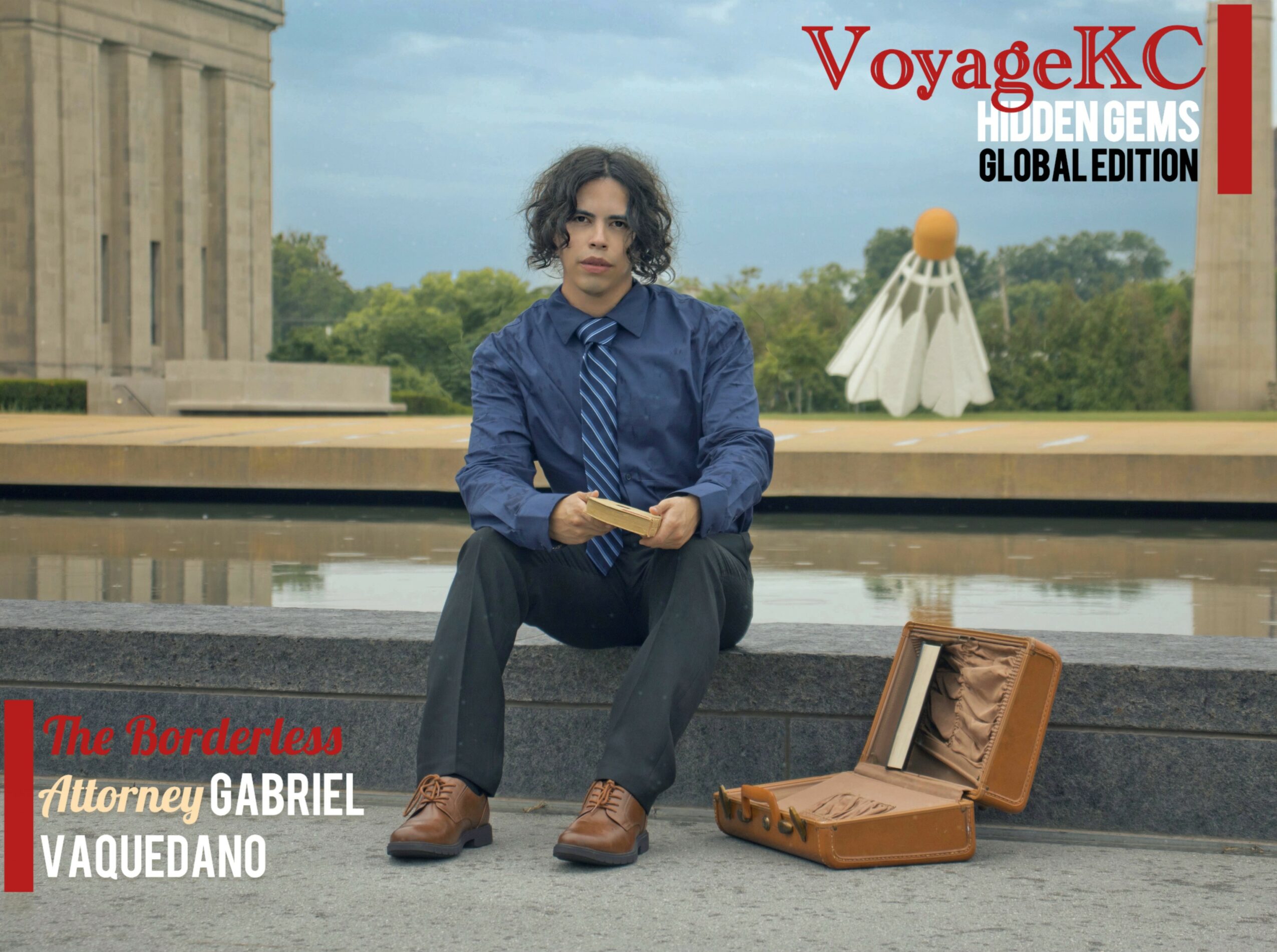 Person sitting on a ledge with a briefcase open, outdoors with a fountain and monument in background.