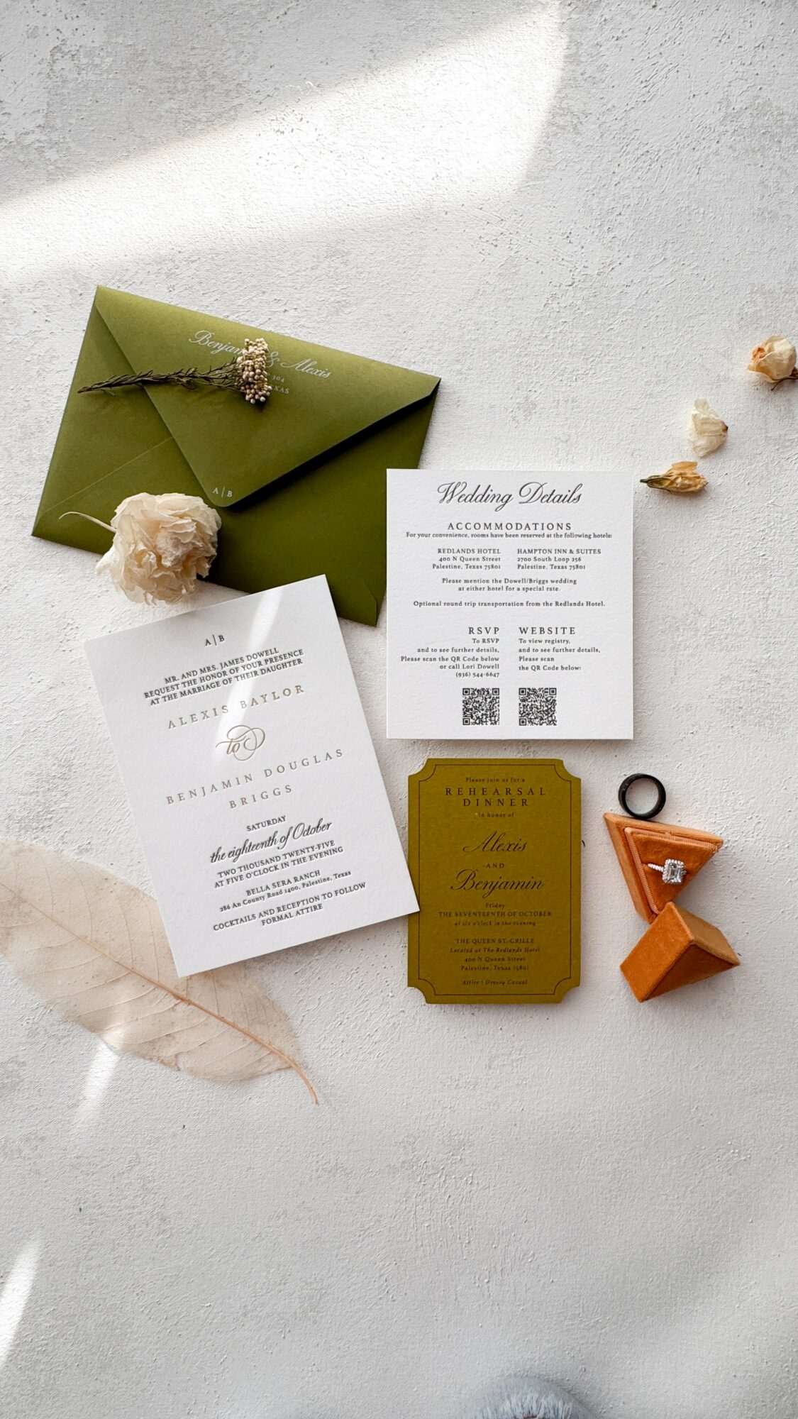 Wedding invitation cards, green envelope, and decorative items on a light surface, with a shadow cast across the scene.