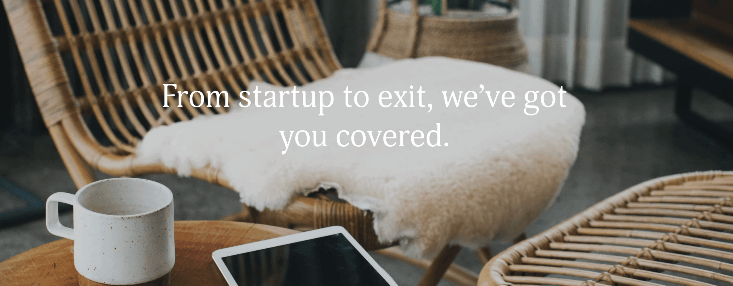 Cozy interior with a chair, mug, tablet, and blanket, with text overlay about startup support.