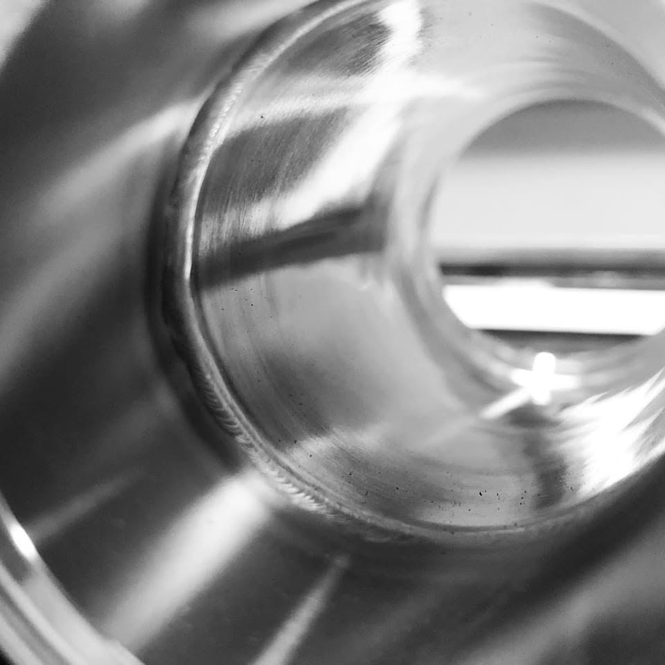 Close-up of a metallic cylindrical object with a smooth, reflective surface and a hollow interior.