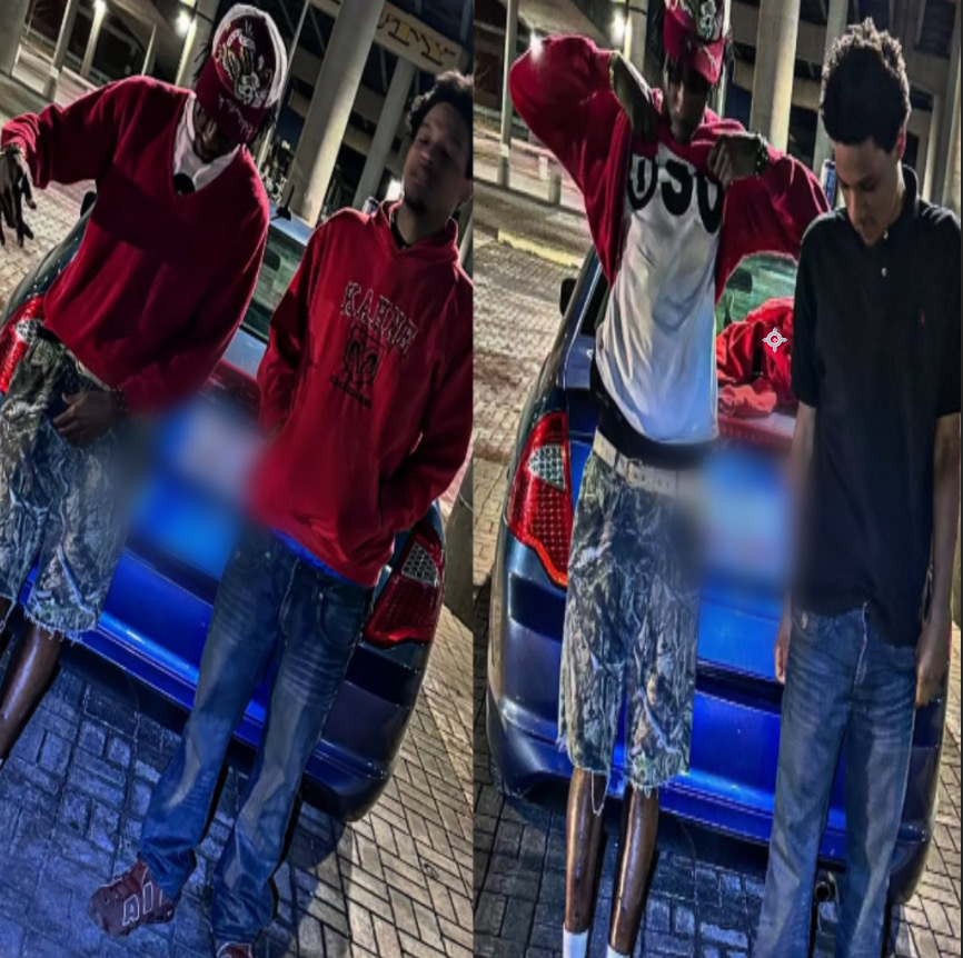 Two young men standing outdoors near a blue car, one wearing a red hoodie and the other in a black shirt, at night.