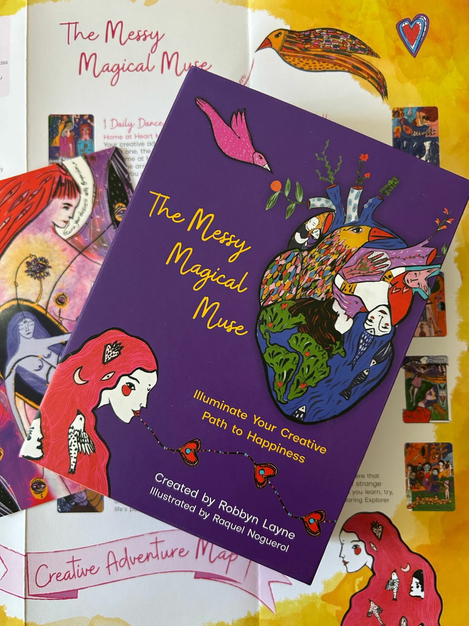 Colorful book cover titled 'The Messy Magical Muse' with illustrations of a pink bird, a unicorn, and a woman with red hair.
