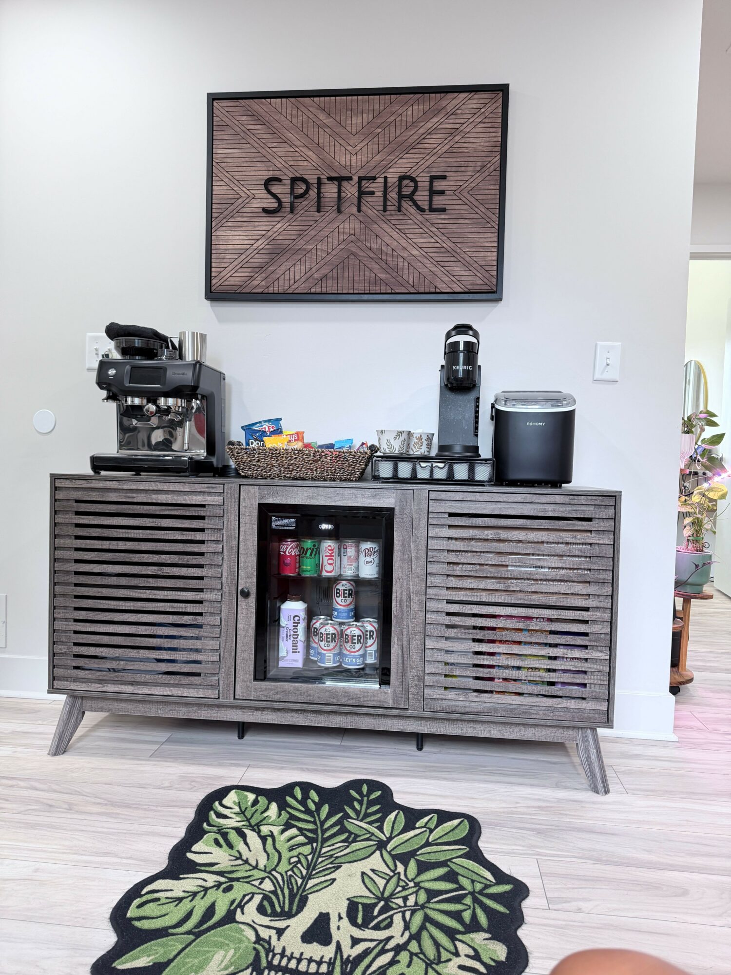 Bar area with coffee machine, drinks, and a wooden cabinet, with a