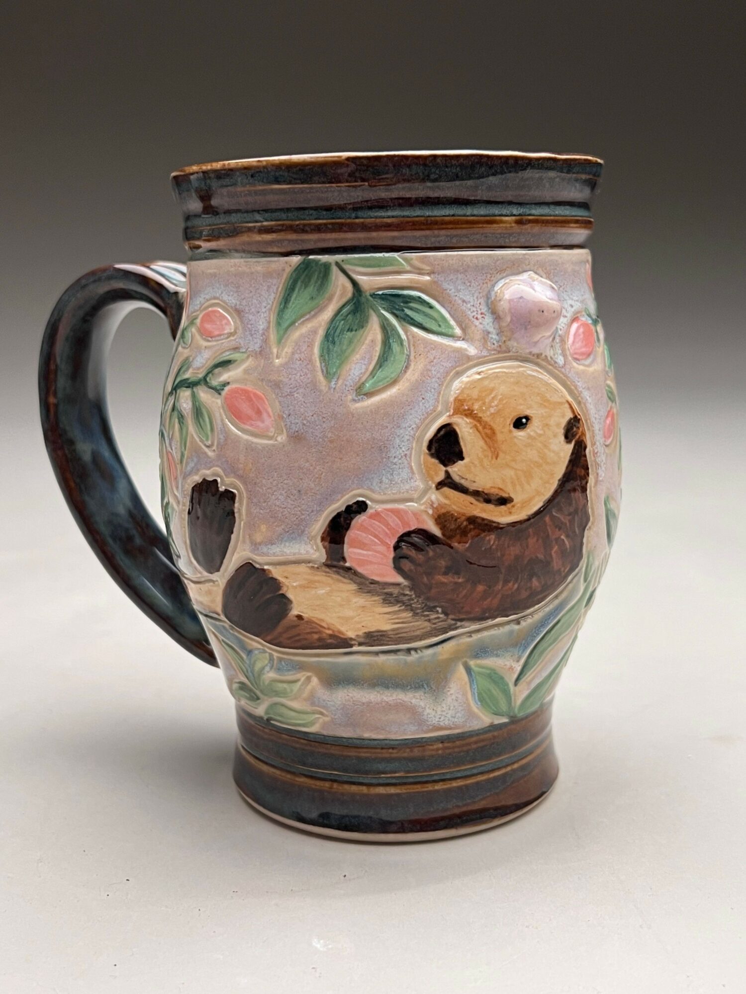 Decorative ceramic mug with a dog illustration, floral design, and a handle, placed on a white surface.