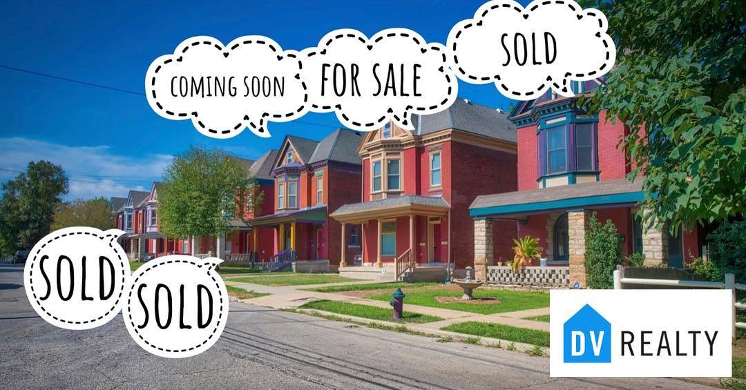Row of colorful houses with signs indicating coming soon, for sale, and sold, in a neighborhood street.
