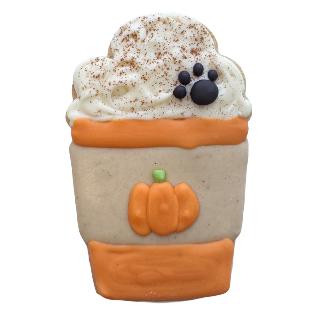 Decorative cookie shaped like a pumpkin in a pot with whipped topping and black berries, topped with cinnamon. Word count: 20
