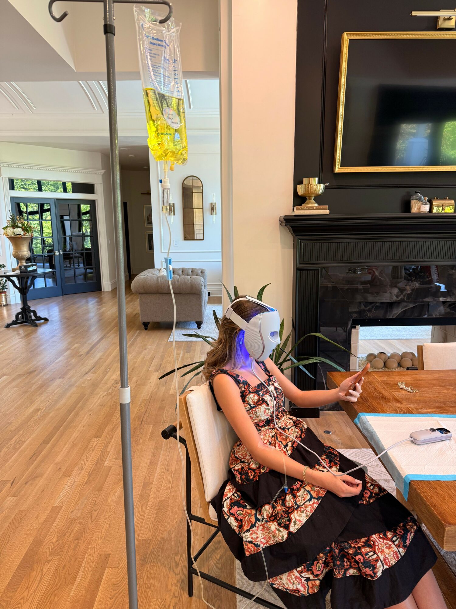 Child sitting at a table with a laptop, in a room with a TV, window, and wooden floor.