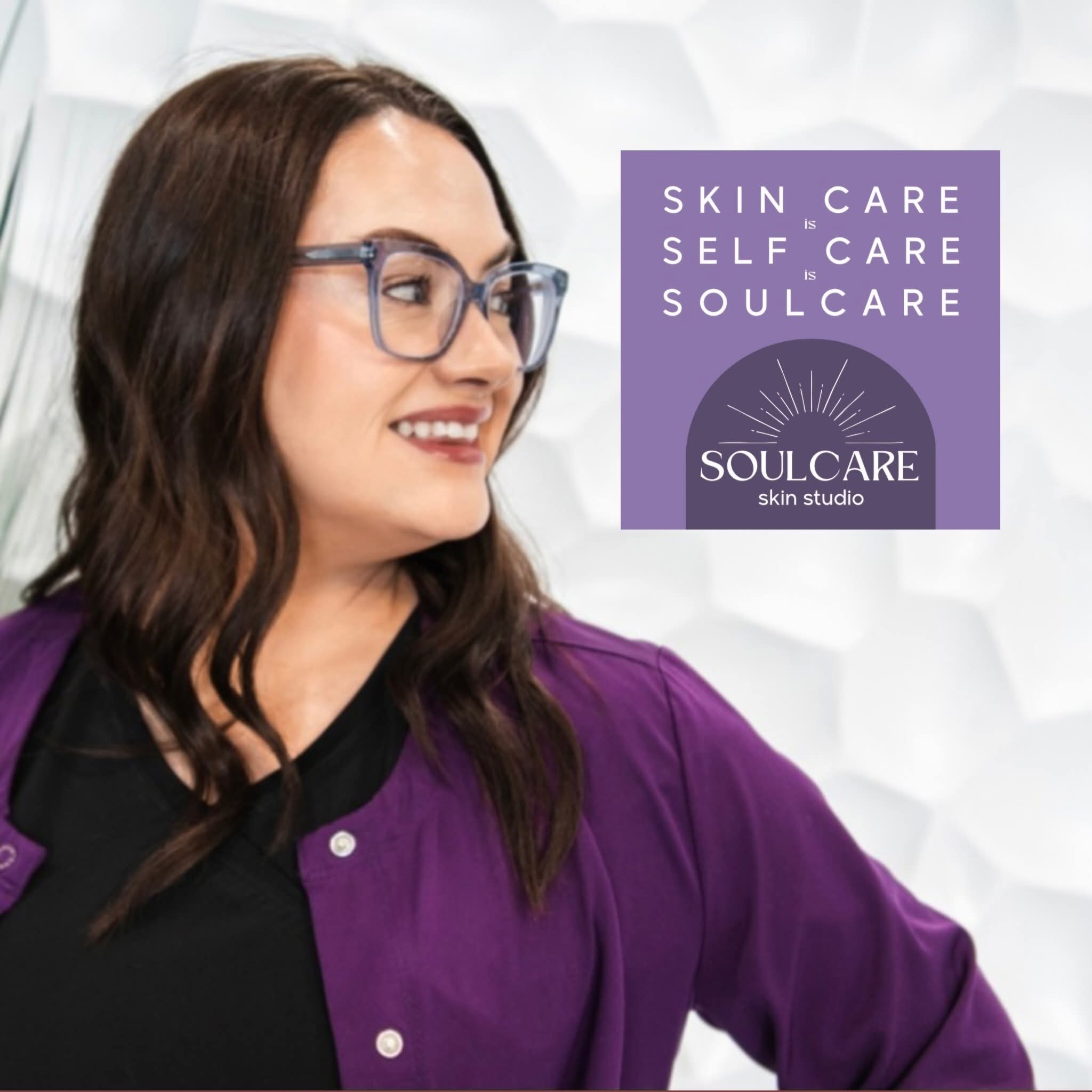 Woman with glasses smiling, wearing a purple jacket, in front of a purple and white sign for Soulcare skin studio.